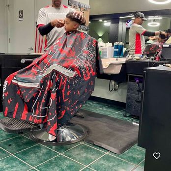 Client getting a fresh fade at Marveliz Cutz with both barber stations active