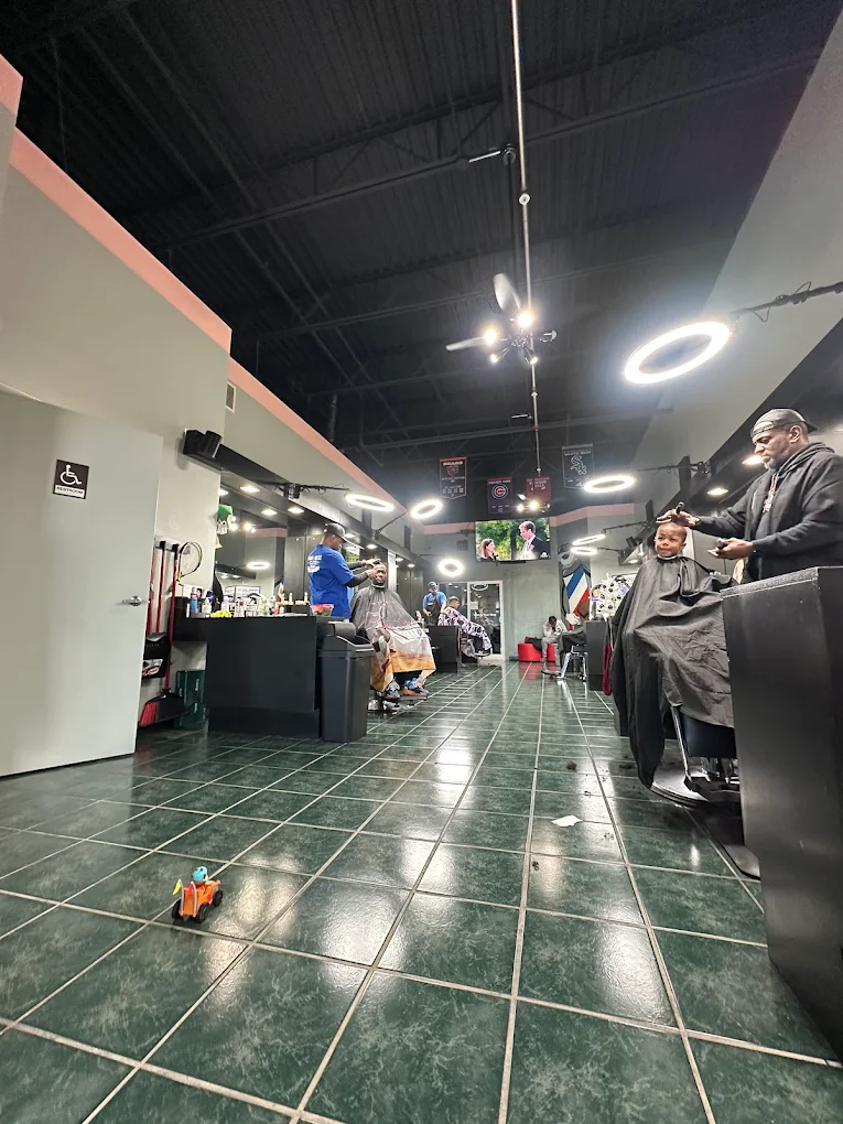Inside Marveliz Cutz — both barbers working with clients in the spacious Madison barbershop